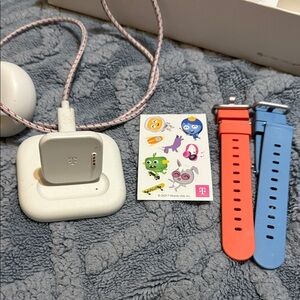 White Smartwatch Charger with Blue and Red Straps